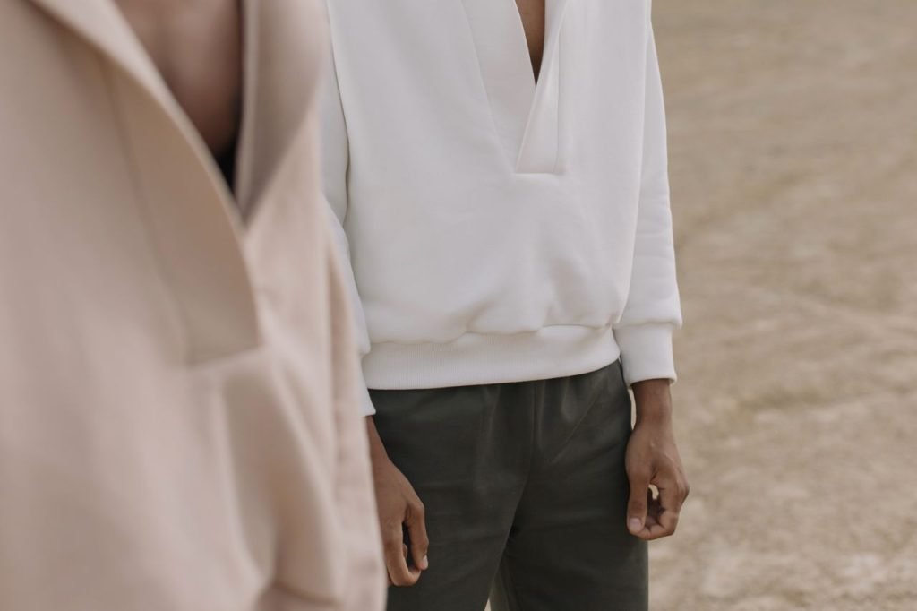 Mastering the First Impression: Your intriguing post title goes here Stylish mens casual wear featuring a white hoodie and green pants in a minimalist setting.